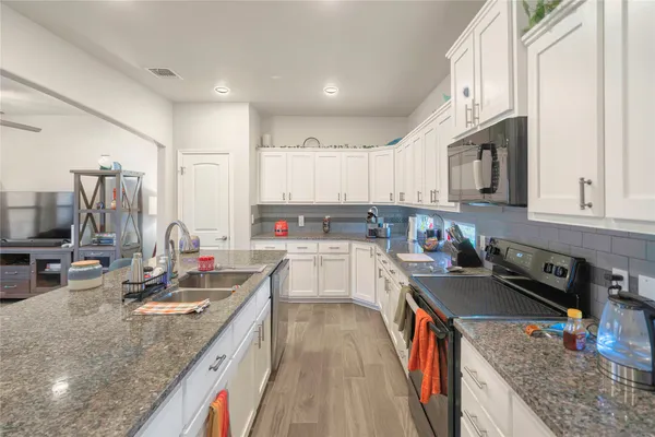 a kitchen with stainless steel appliances granite countertop a sink stove and refrigerator