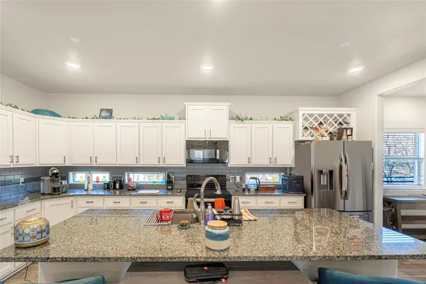 a kitchen with stainless steel appliances granite countertop a refrigerator and stove