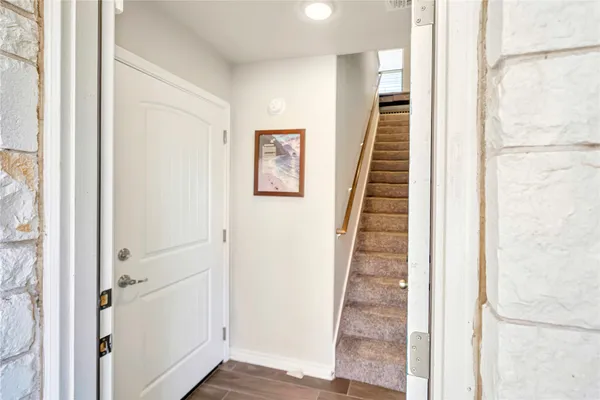 a view of a hallway with wooden floor and entryway