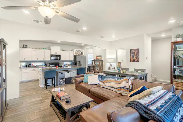 a living room with lots of furniture and kitchen view