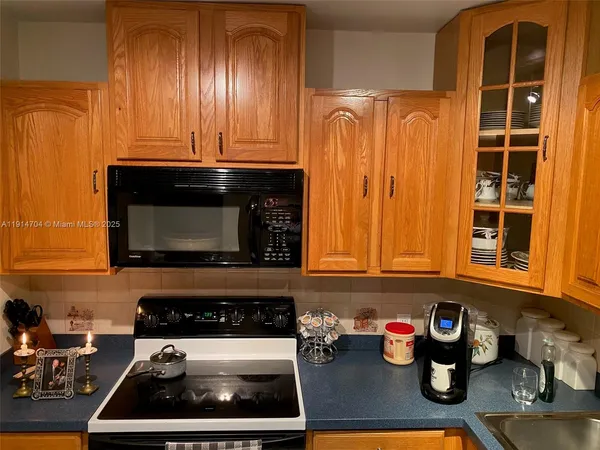 a kitchen with granite countertop cabinets stove top oven and microwave