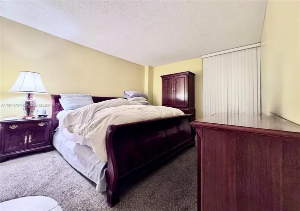 a bedroom with a bed lamp and a window