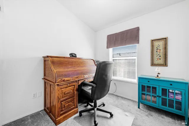 a view of a workspace with furniture and a window