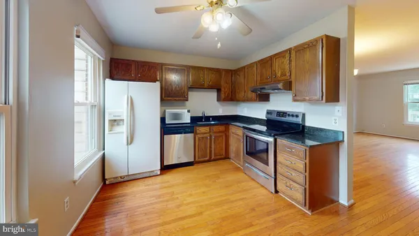 a kitchen with stainless steel appliances a refrigerator a sink a stove a microwave and cabinets