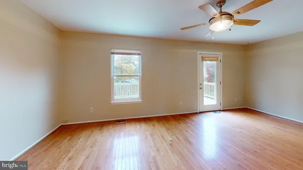 a view of room with window ceiling fan and wooden floor
