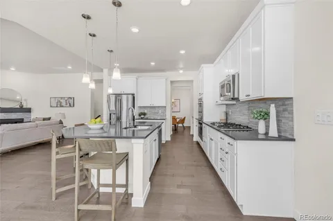 a large white kitchen with lots of counter space a sink appliances and cabinets