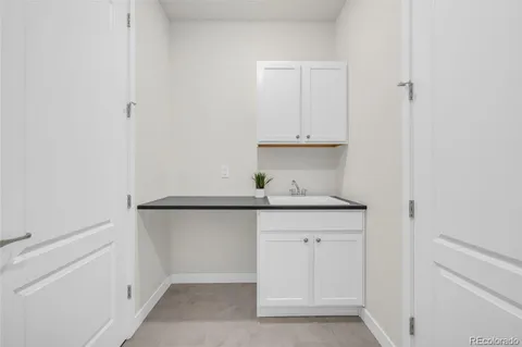 a kitchen with white cabinets and sink