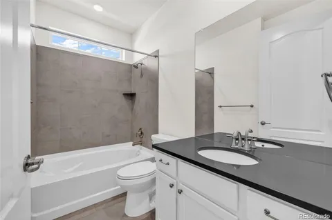 a bathroom with a granite countertop sink toilet and shower