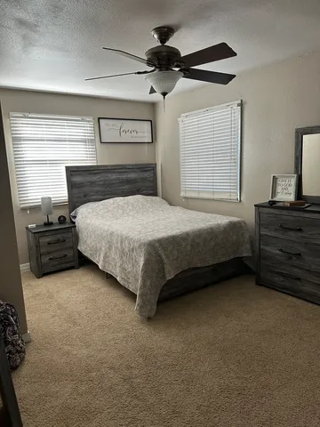a spacious bedroom with a bed and a dresser