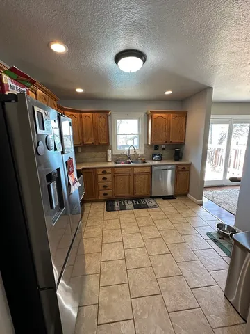 a kitchen with stainless steel appliances a refrigerator sink and microwave