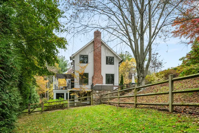 a view of yellow house with a large window and yard