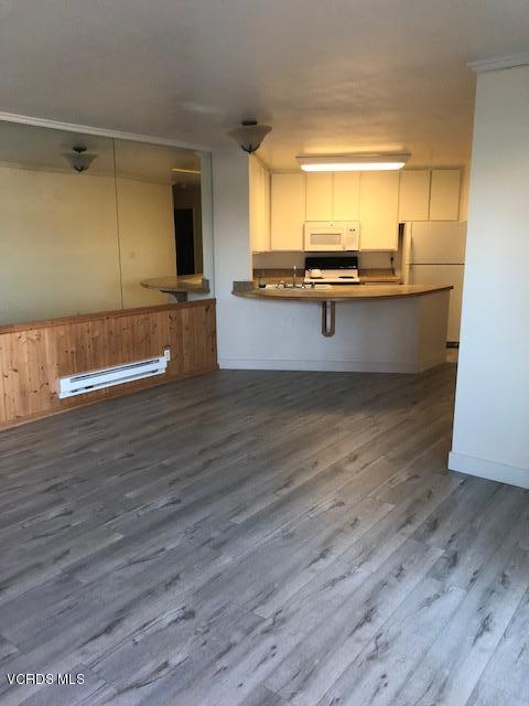 3101 Peninsula Road, Unit 104 Oxnard, CA 93035 - Photo 5 of 29 a view of kitchen with wooden floor and electronic appliances