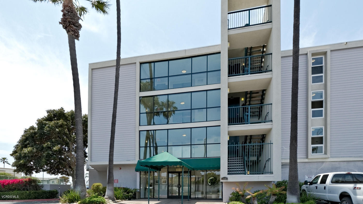 3101 Peninsula Road, Unit 104 Oxnard, CA 93035 - Photo 10 of 29 a front view of a building with a plants and a yard