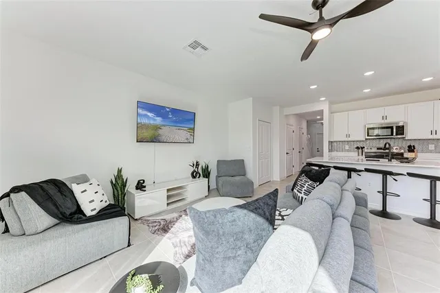 a living room with furniture kitchen view and a window