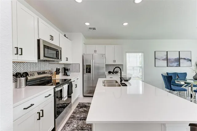 a kitchen with stainless steel appliances a stove sink microwave and cabinets