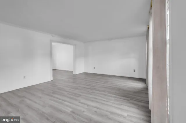 an empty room with window and wooden floor