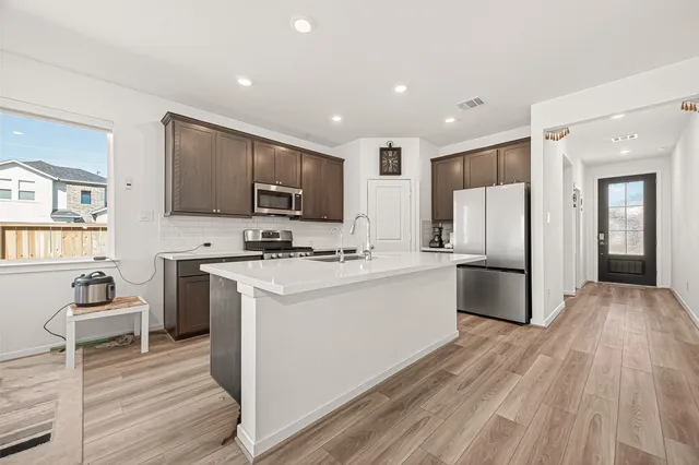 a kitchen with stainless steel appliances granite countertop a refrigerator stove microwave and sink