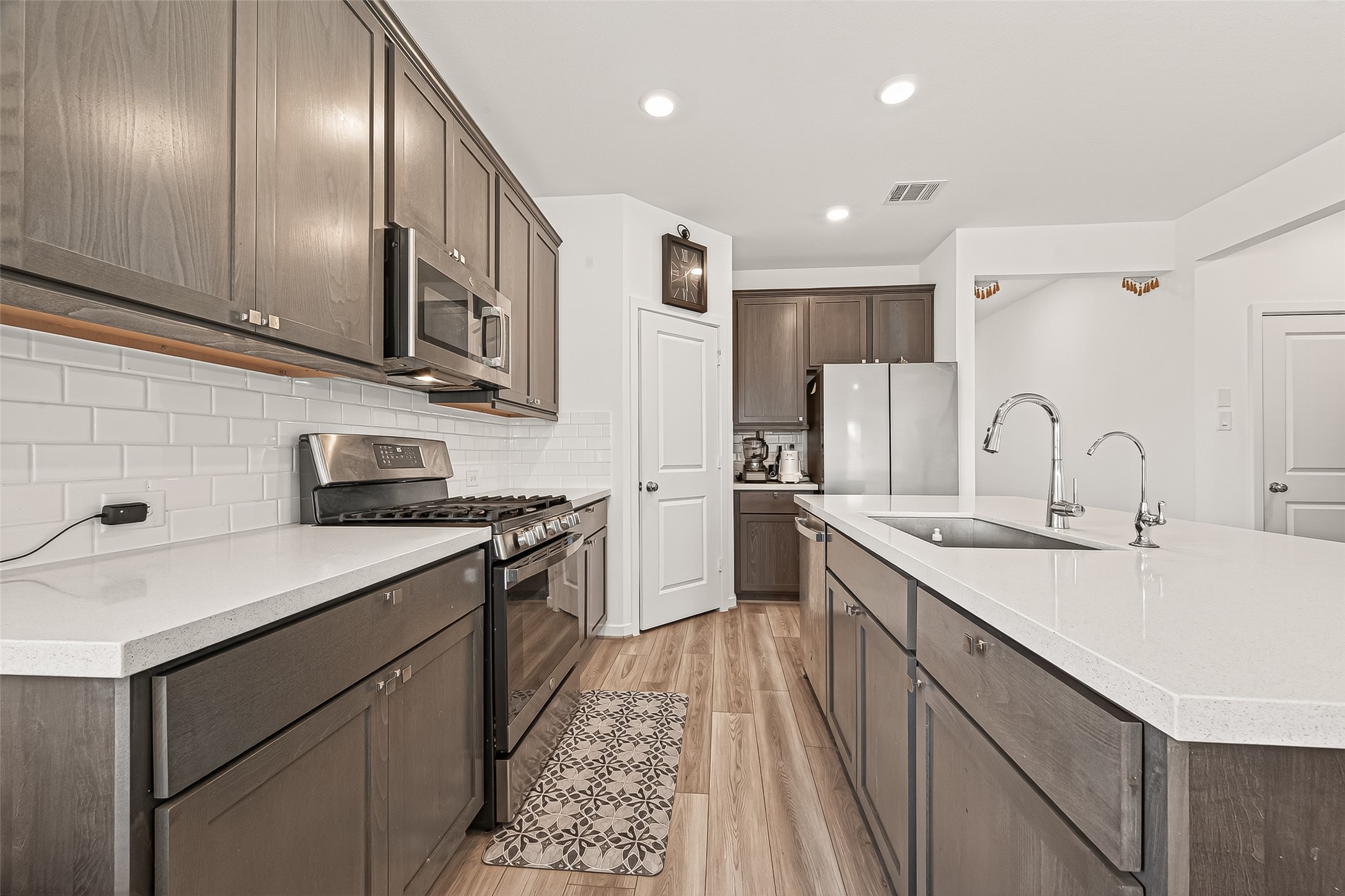 9747 Pettus Crk Drive Cypress, TX 77433 - Photo 19 of 48 a kitchen with stainless steel appliances granite countertop cabinets a sink a stove a refrigerator and a oven