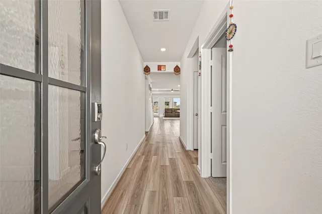 a view of a hallway with wooden floor and staircase