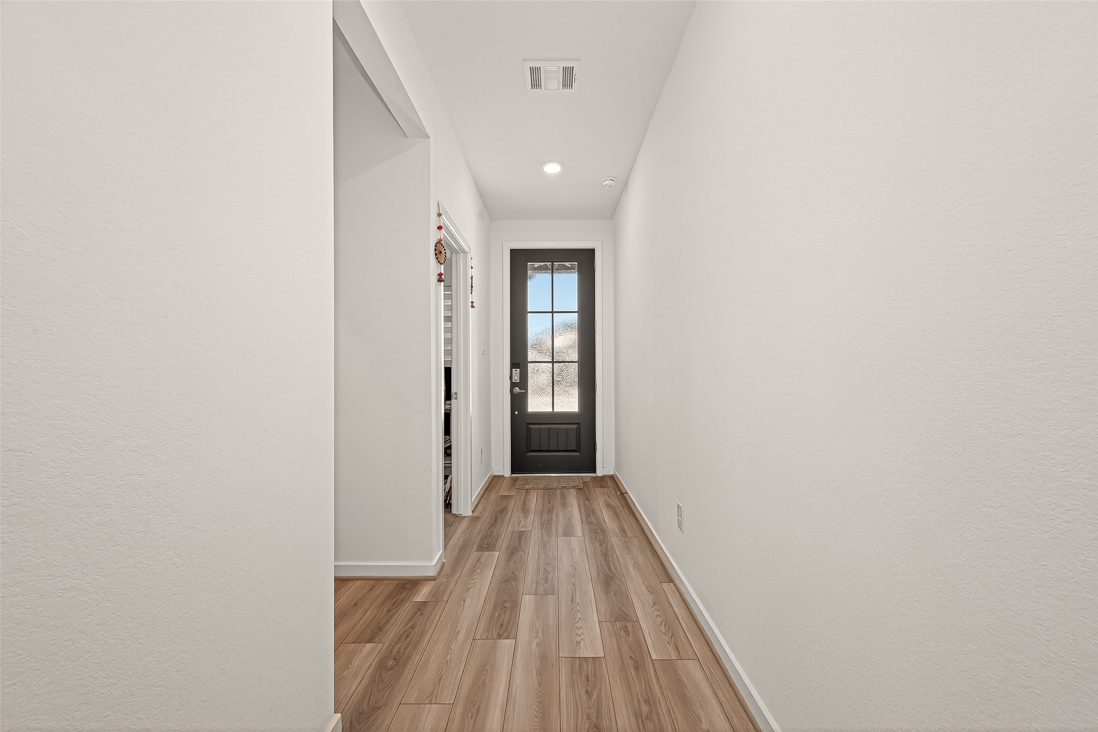 9747 Pettus Crk Drive Cypress, TX 77433 - Photo 8 of 48 a view of a hallway with wooden floor and a bathroom