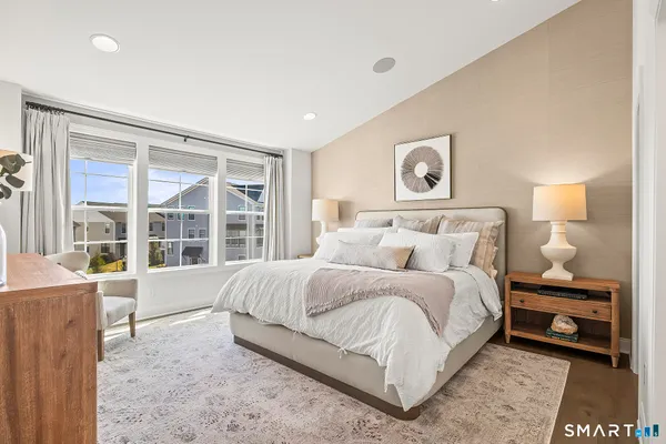 a bedroom with a bed and a large window