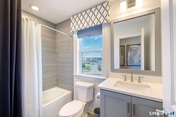 a bathroom with a sink toilet mirror and shower