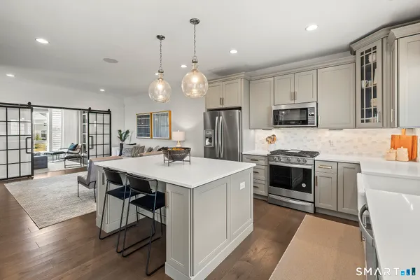 a kitchen with kitchen island a stove a table and chairs in it