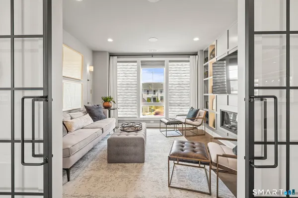 a living room with furniture wooden floor and large window with outer view