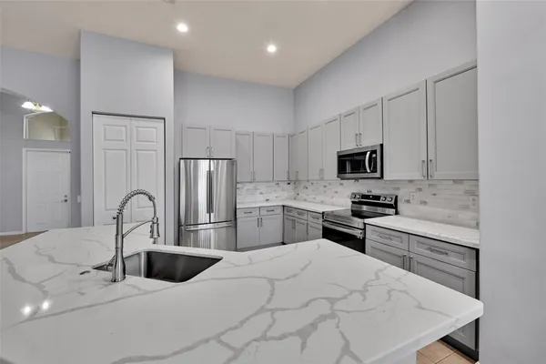 a kitchen with stainless steel appliances a sink microwave and stove