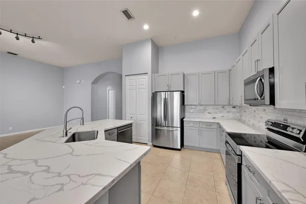 a kitchen with a refrigerator sink and wooden cabinets