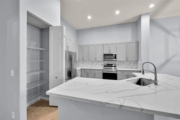 a kitchen with kitchen island a sink stainless steel appliances and cabinets