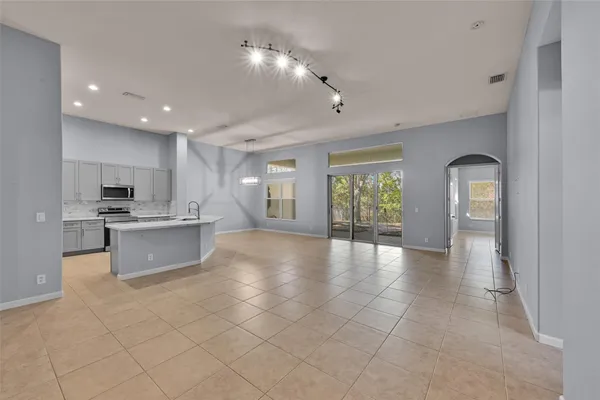 a large kitchen with stainless steel appliances a large counter top and a stove