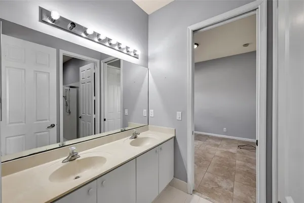 a bathroom with a double vanity sink and a mirror