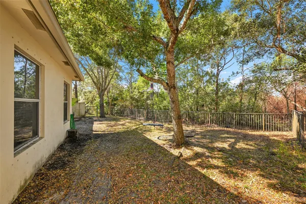 a view of a yard with wooden fence and trees