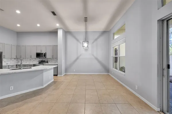 a large kitchen with kitchen island a sink stainless steel appliances and cabinets