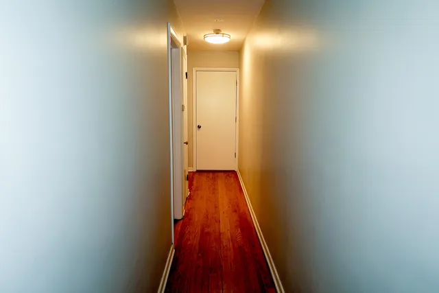a view of a hallway with wooden floor
