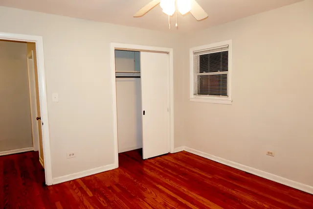 an empty room with wooden floor and closet