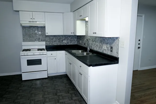 a kitchen with granite countertop white cabinets and white appliances