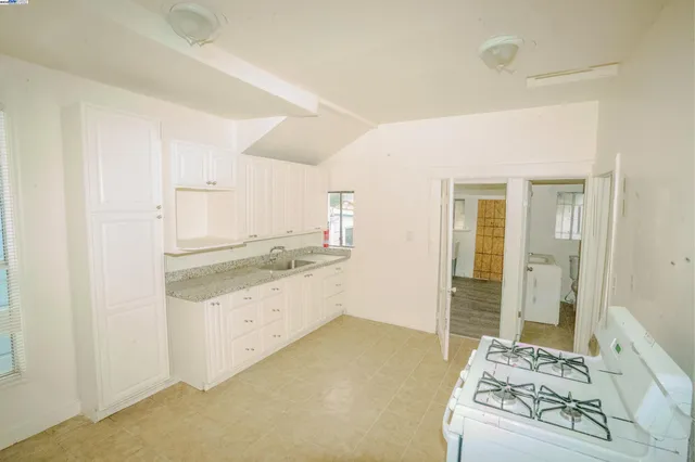 a large white kitchen with granite countertop a sink