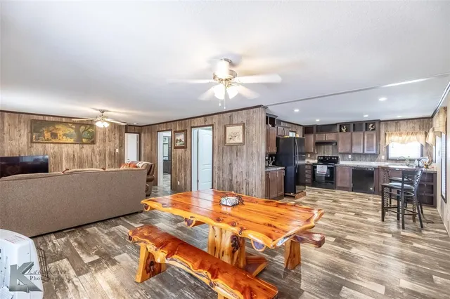 a living room with furniture a table and kitchen view