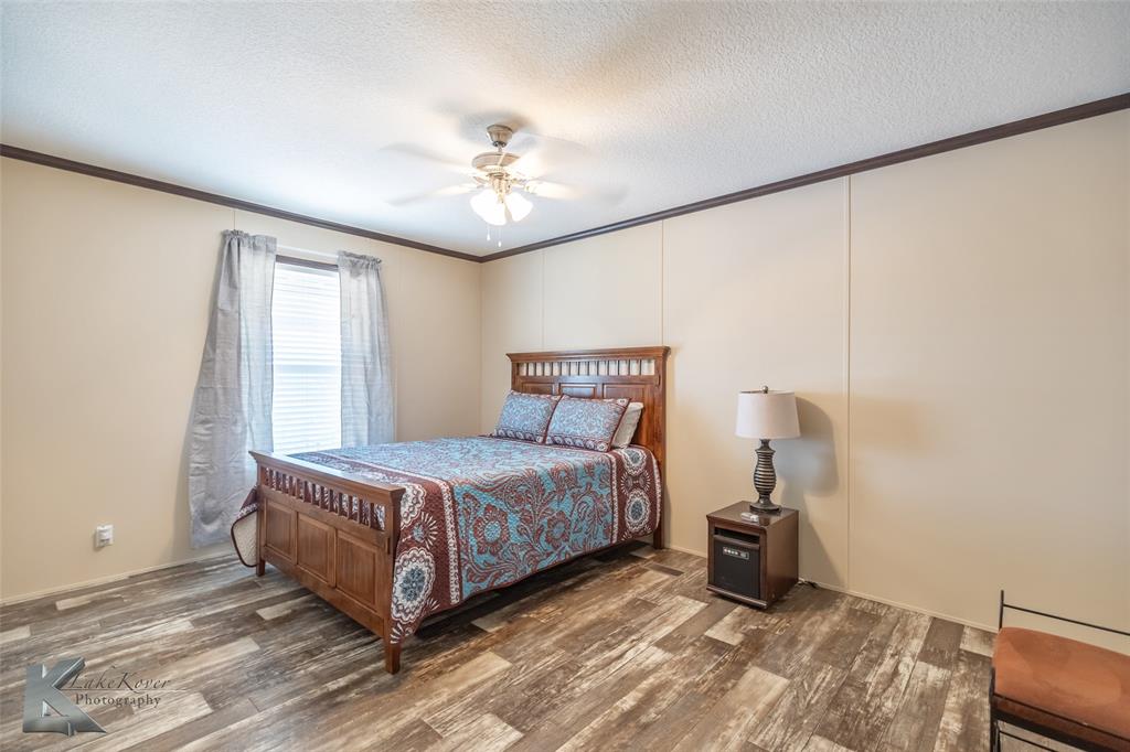 2302 County Road 360 Merkel, TX 79536 - Photo 15 of 39 a bedroom with a bed and a ceiling fan
