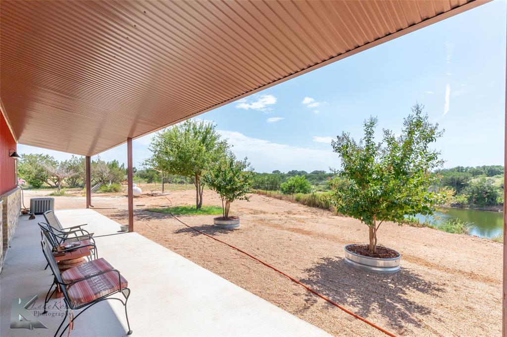 2302 County Road 360 Merkel, TX 79536 - Photo 19 of 39 a view of a patio with table and chairs potted plants with wooden fence