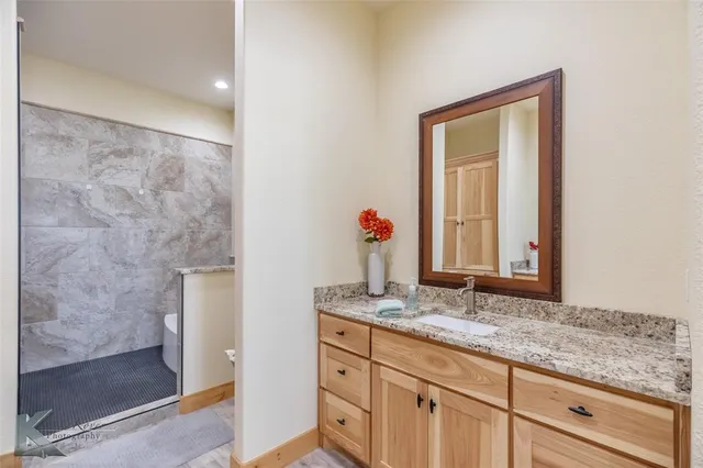 a bathroom with a granite countertop sink and a mirror