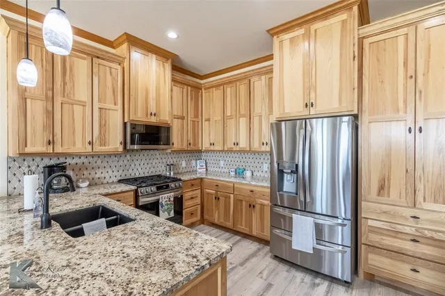 a kitchen with stainless steel appliances granite countertop a refrigerator sink and cabinets
