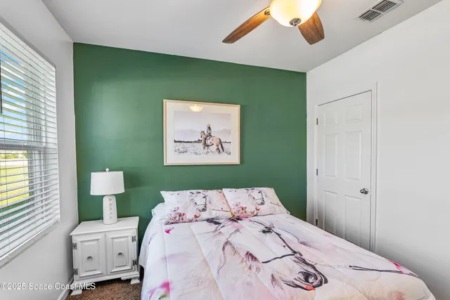 a bedroom with a bed and a painting on the wall