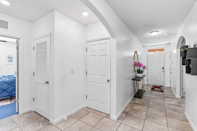 a view of a hallway to dining room and chandelier