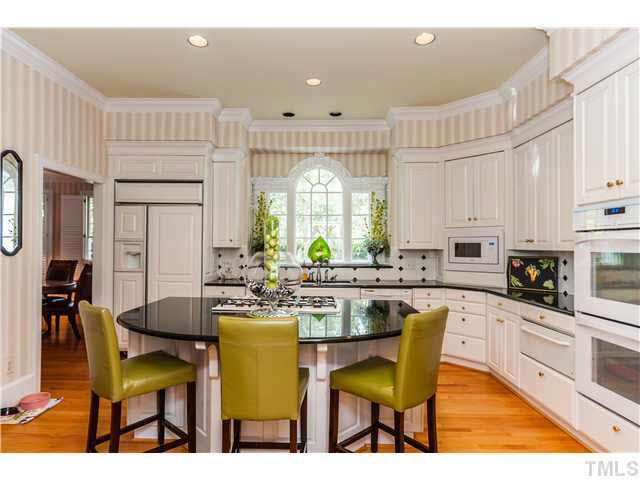 405 Lake Boone Trail Raleigh, NC 27608 - Photo 4 of 24 a kitchen with a dining table chairs refrigerator and cabinets