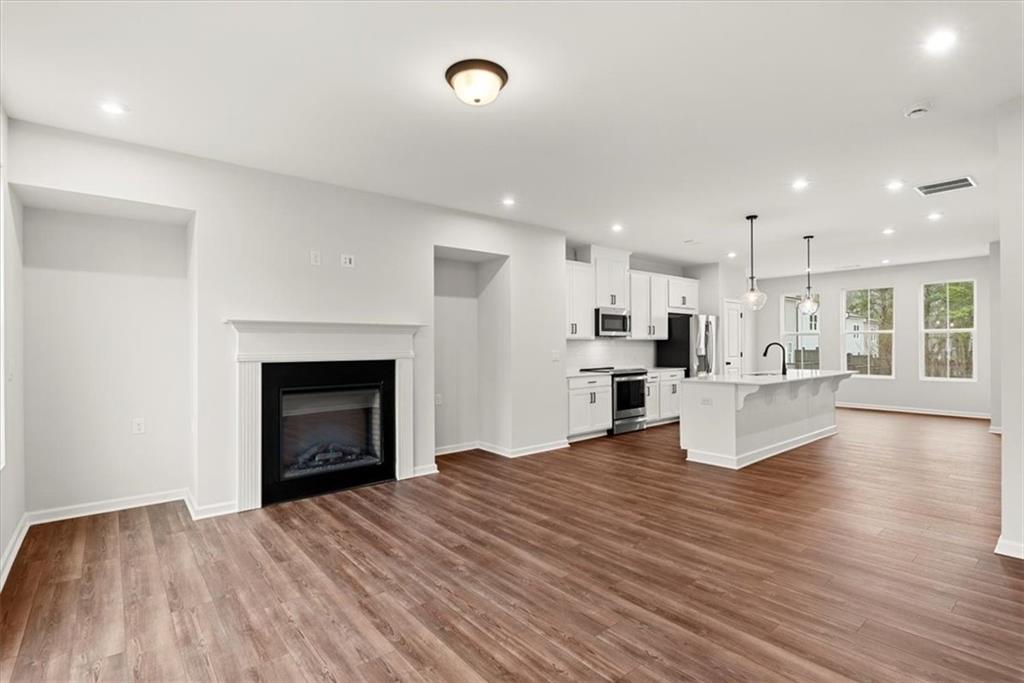 741 Payton Lane Acworth, GA 30102 - Photo 17 of 36 a view of kitchen and hall with wooden floor and a fireplace