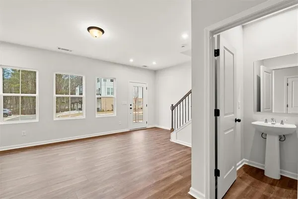 an empty room with wooden floor and windows