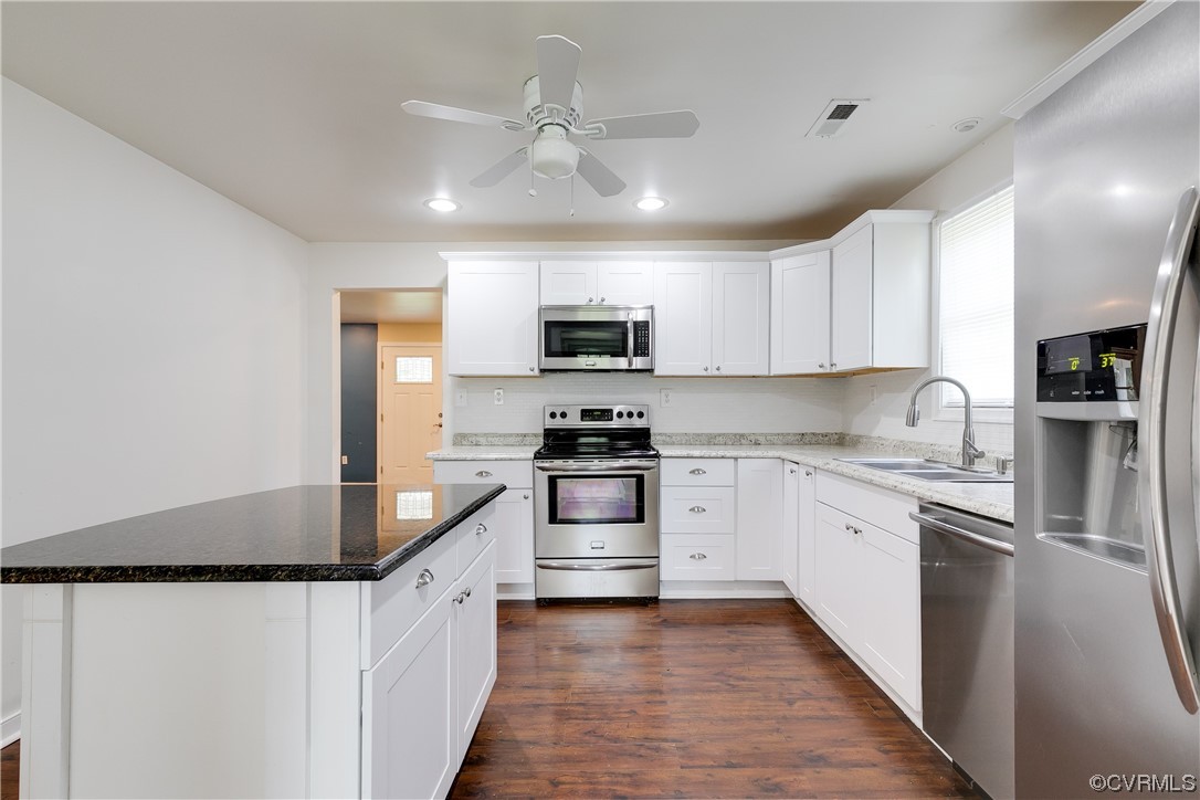 4144 Broad St Road Gum Spring, VA 23065 - Photo 17 of 34 a kitchen with stainless steel appliances granite countertop a stove top oven a sink dishwasher and a refrigerator with wooden floor